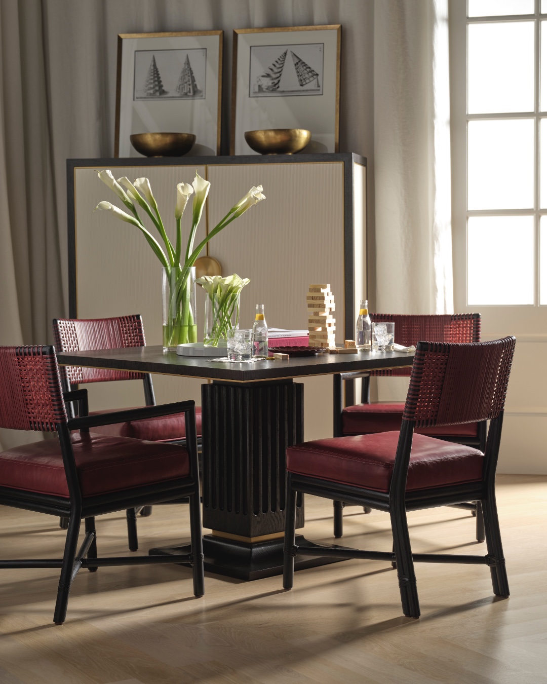 The Alameda Dining Arm and Side Chairs are inspired by the popular Antalya(TM) Collection which is crafted by wrapping rawhide around a rattan frame. A study in rawhide weaving, interlocking rawhide straps are wrapped to make an intricate and comfortable pattern on the back. Custom rawhide program available. Also featuring the Trocadero Game Table and the Odeon Cabinet from the Thomas Pheasant Collection for @BakerFurniture. Visit the link in our bio for more information. #thisismcguire #customrawhide